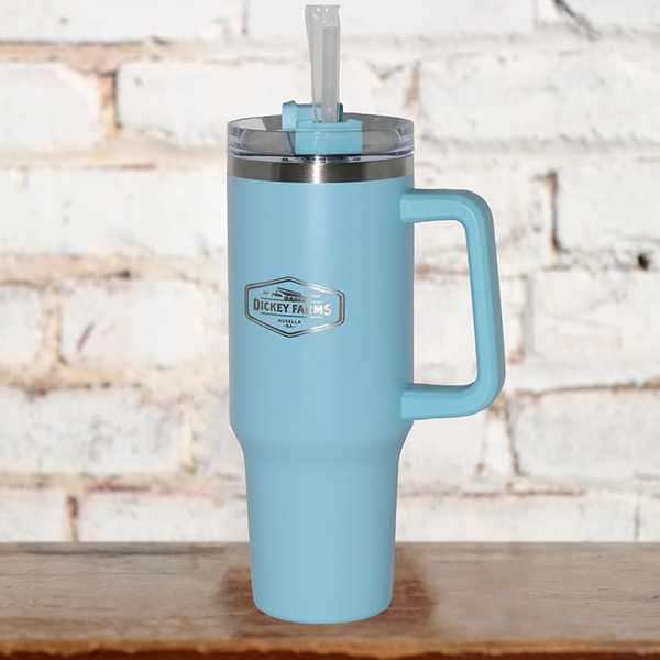 a light blue tumbler from dickey farms sits on a wooden table