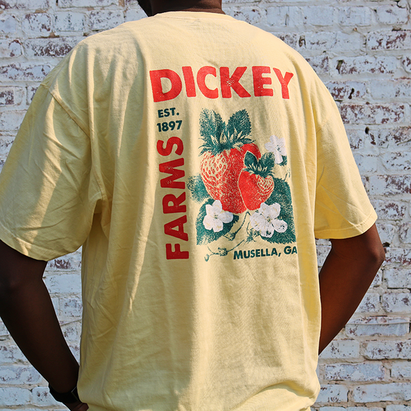 a man is wearing a yellow shirt that says dickey farms