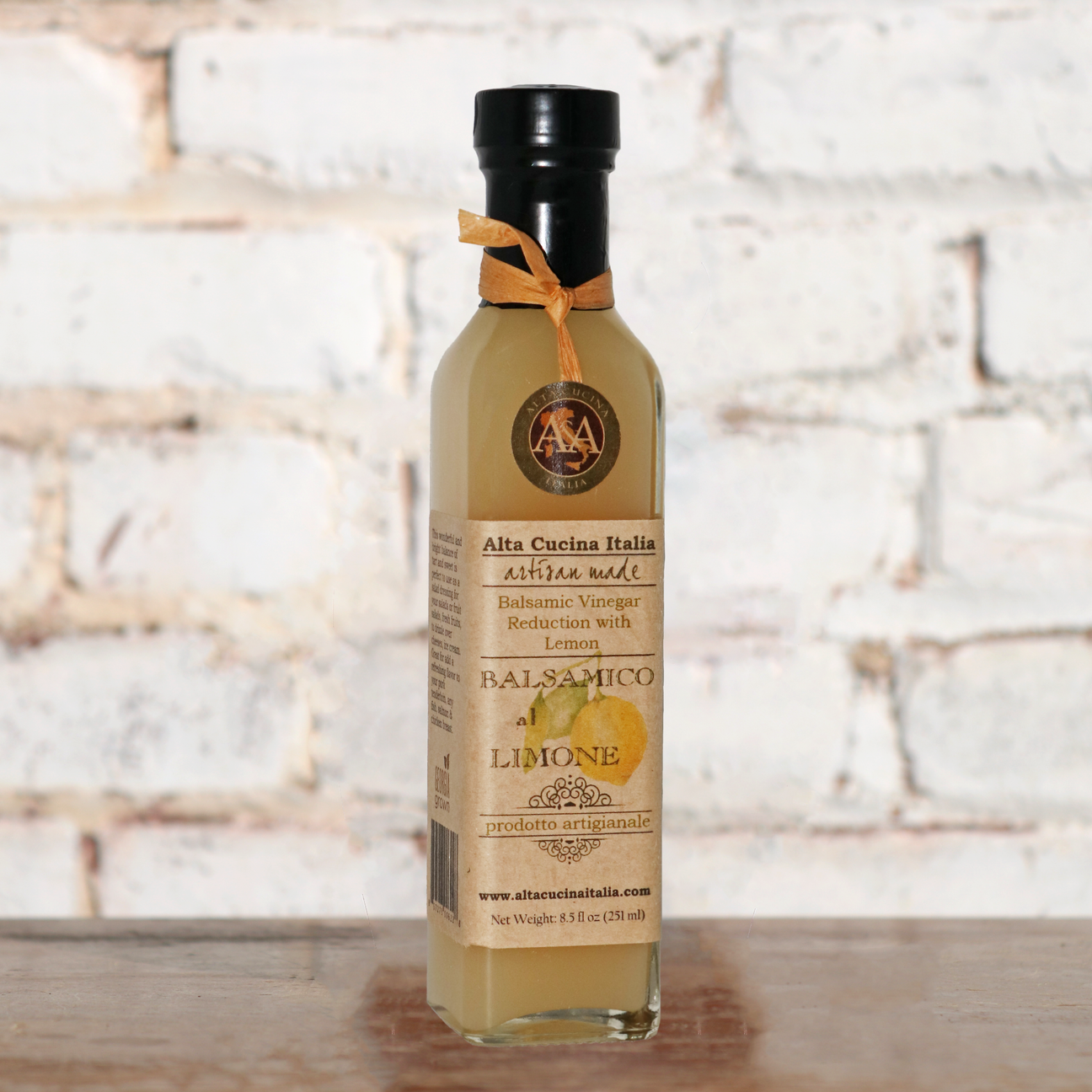 a bottle of balsamic vinegar sits on a wooden table