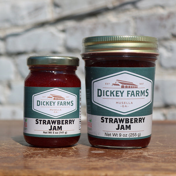 two jars of dickey farms strawberry jam on a table