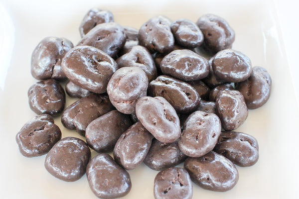 a pile of chocolate covered pecans on a table .