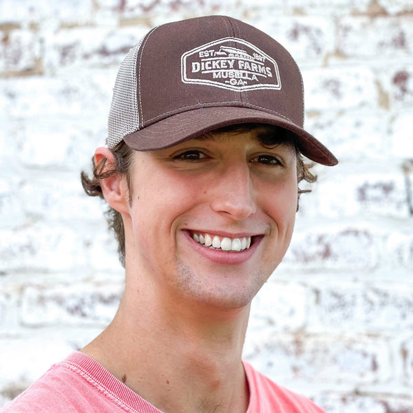 a man wearing a hat that says dickey farms on it