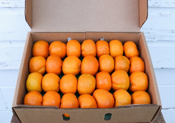 a cardboard box filled with oranges