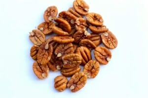 a pile of pecans on a white surface .