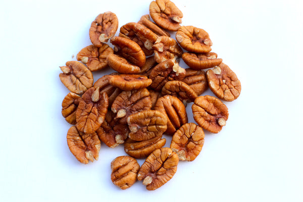 a pile of pecans on a white surface .